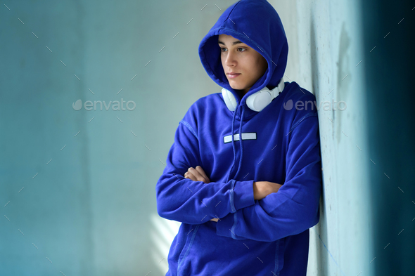 Thoughtful serious teenage boy in a blue hoodie